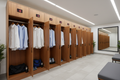 Corporate wellness center locker room with combination locker columns, dress shirts hanging, gym bag on lower shelf