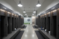 University athletic facility locker room with two facing rows of signature phenolic locker banks, player name plates, custom logos